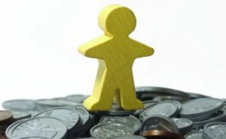 Yellow human figure standing on pile of fake money