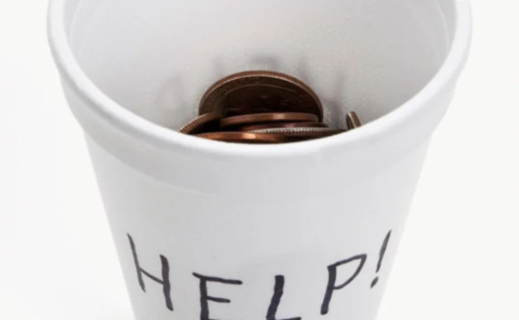 A begging cup half full of change