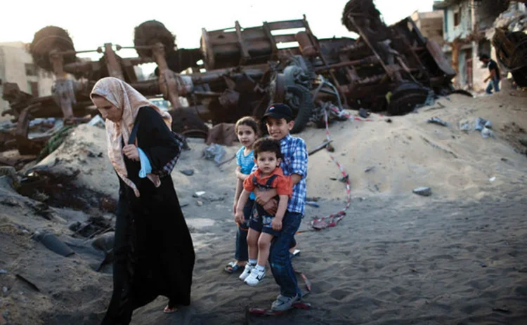A family walk down a bombed street in Libya