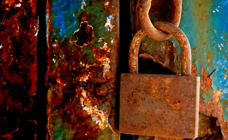open-rusty-padlock-on-crumbly-painted-door