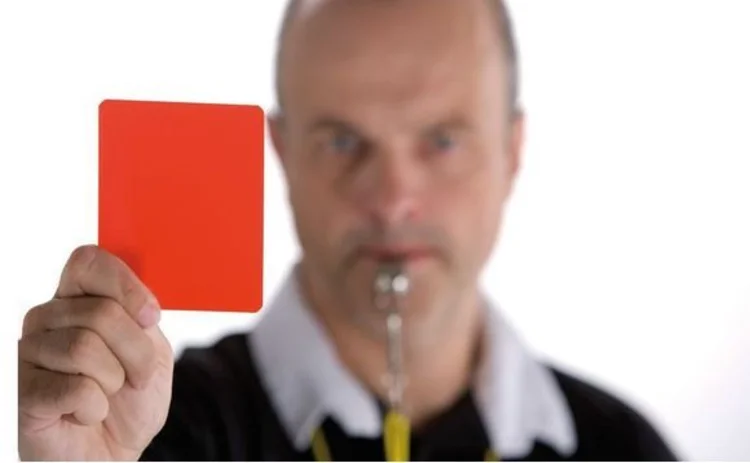 Referee brandishing a red card