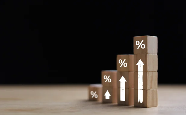 Wooden blocks with percentage signs showing an upward trend