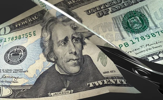 Scissors cut a US $20 bill