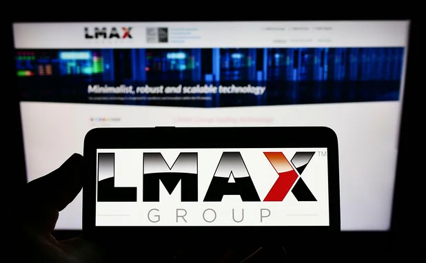 Mobile phone and computer screen with LMAX logo and website