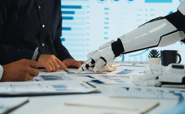 A robot points at some charts, helping humans to analyse the data 