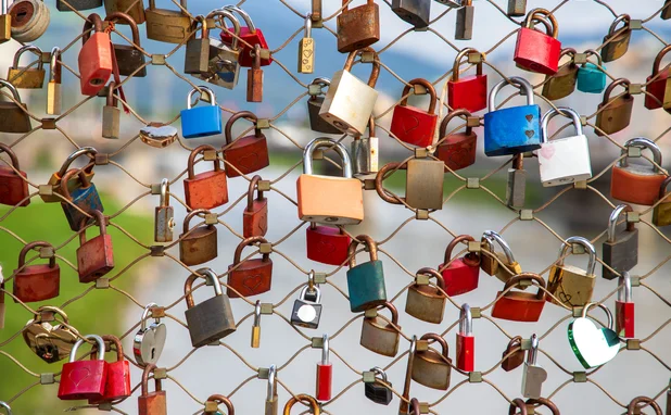 colourful padlocks locked to a wire fence