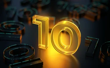 A glowing rendition of the number ten standing in the middle of non-glowing number 10s lying flat on the ground