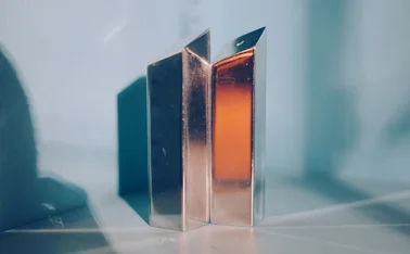 Gold blocks in a white room reflecting light and symbolizing prestige