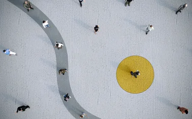 Aerial view of people walking across a large open plaza with minimalist design, featuring a yellow circular zone and a curved pathway. The image highlights social distance, urban movement, and modern public space architecture. 