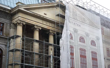 Scaffolding on the Palace of the University of Bucharest’s facade is half-covered by an idealised version printed on a sheet