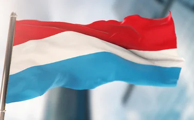 Luxembourg flag against defocused city buildings