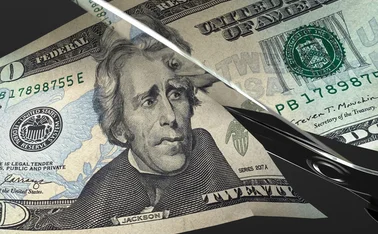 Scissors cut a US $20 bill