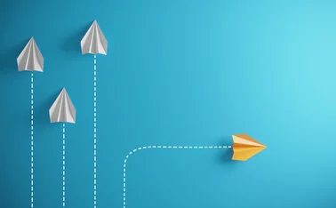 three paper aeroplanes are rising upwards, while one in a different colour goes off to the side