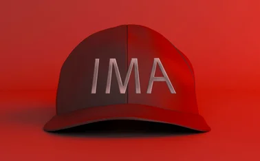 A red ‘maga-style’ baseball cap has the letters IMA written on it