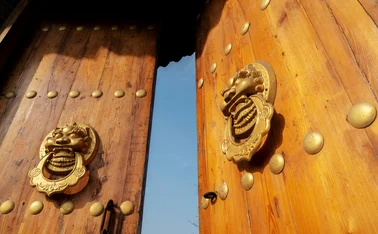 Traditional Chinese doors with dragon knockers ajar 