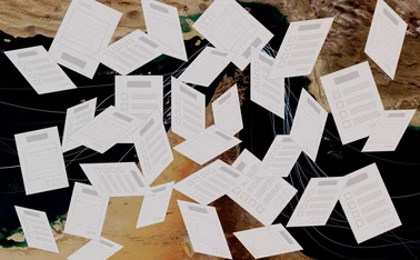 Exam papers fly randomly in front of a backdrop of the strait of hormuz