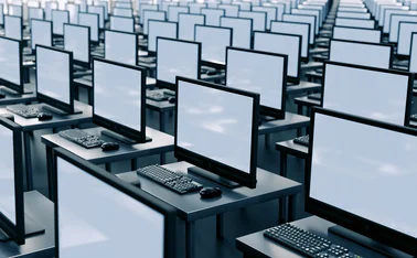 Countless computer screens in a room, receding into the distance