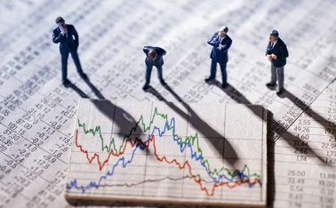 Small plastic figurines of businesspeople look quizzically at a large financial chart