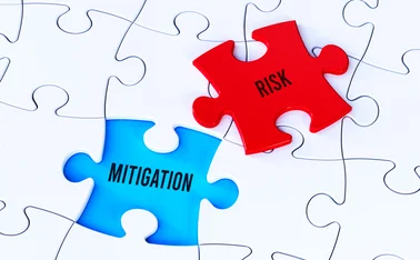 White jigsaw puzzle with displaced red piece that has the word Risk on it, which could fit into a blue gap that shows the word Mitigation