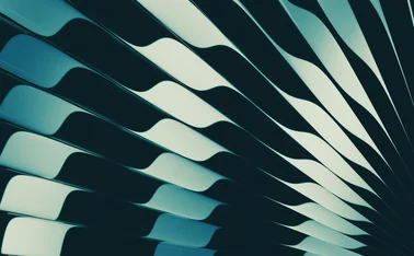 Abstract close-up featuring flowing curved lines in deep teal, black, and pale blue tones, creating a modern geometric pattern with contrasting highlights and shadows.