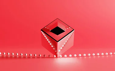 Abstract, reflective, red cube with a dark square opening floating above a row of small white spheres on a pinkish-red background