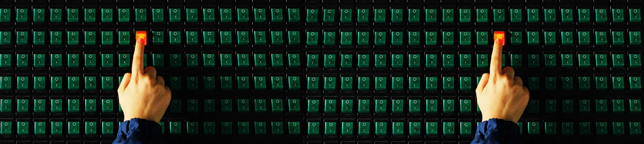 In a sea of green buttons, a finger pushes on a red button