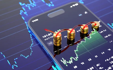 A smartphone showing a graph, with some coins on the screen