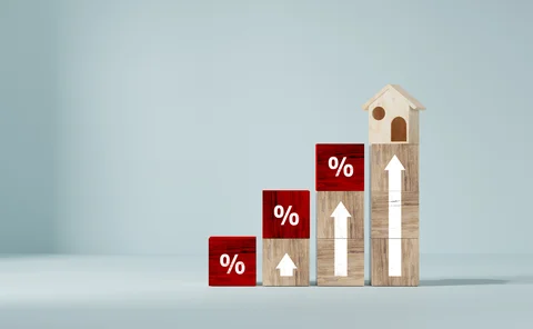 Ascending wooden blocks with up arrows and percentage signs and a house at the top