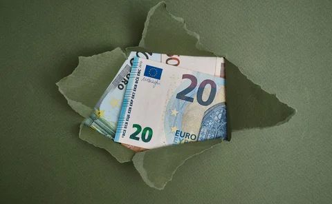 A paper package has been ripped open, revealing euro notes 