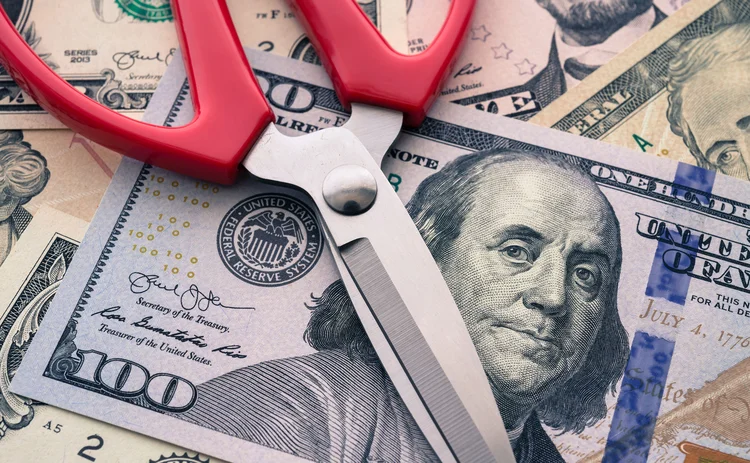 米ドルの上に置かれたはさみ