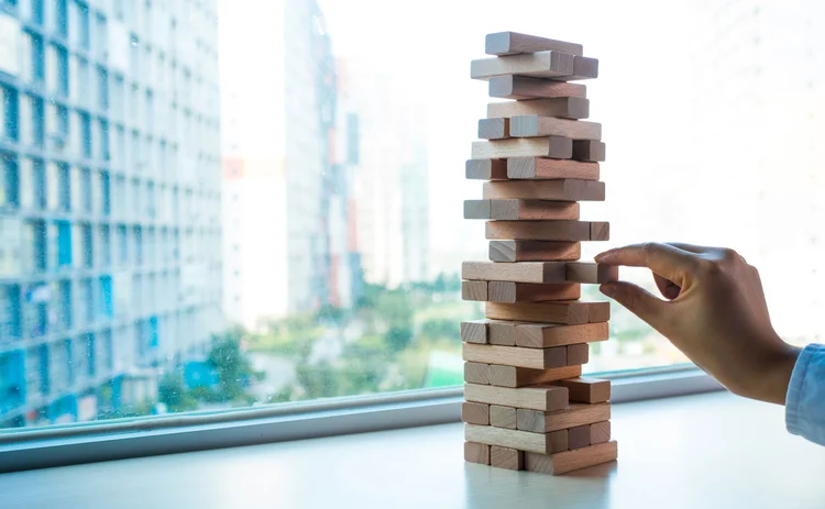 A Jenga game, and someone is pulling one of the wooden blocks out