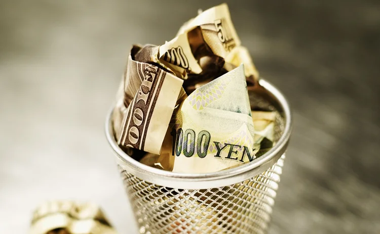 Yen and dollars in wastepaper basket