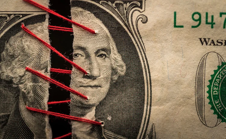 Two pieces of dollar banknote being stitched together