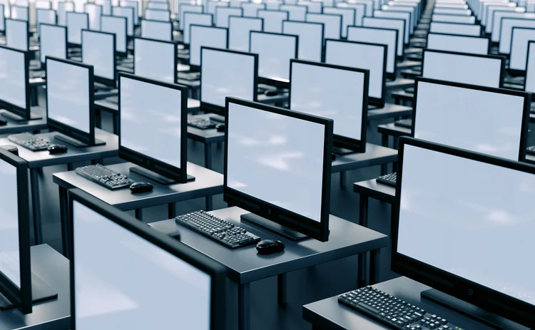 Countless computer screens in a room, receding into the distance