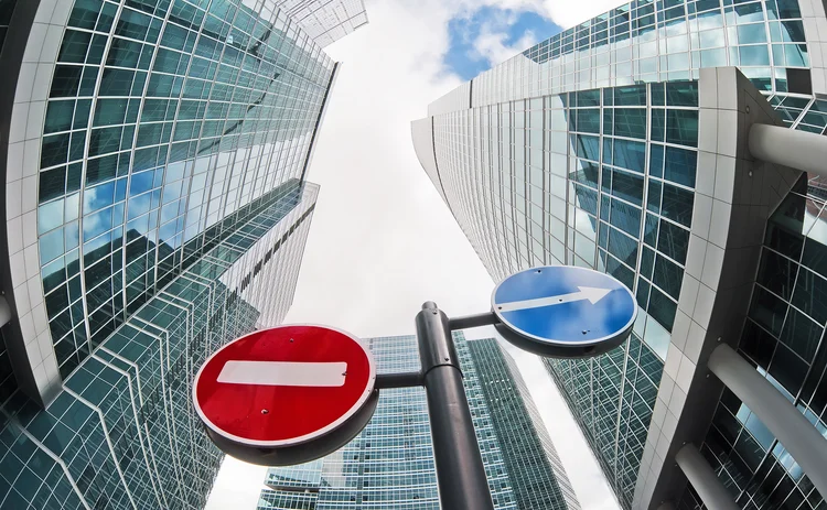 No-entry and diversion road signs on a background of distorted skyscrapers