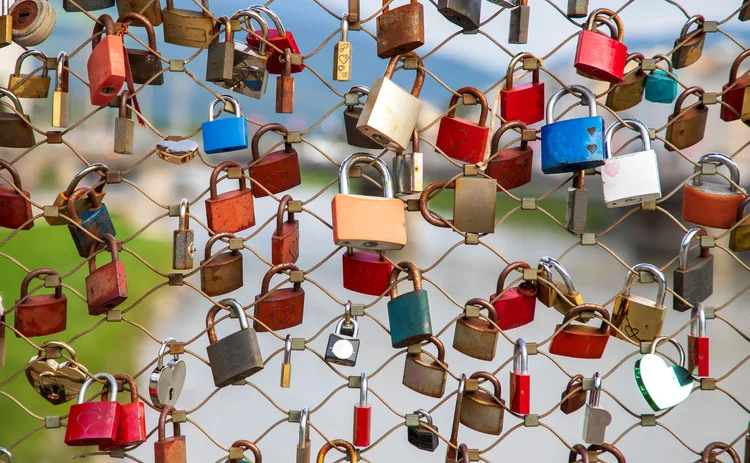 colourful padlocks locked to a wire fence