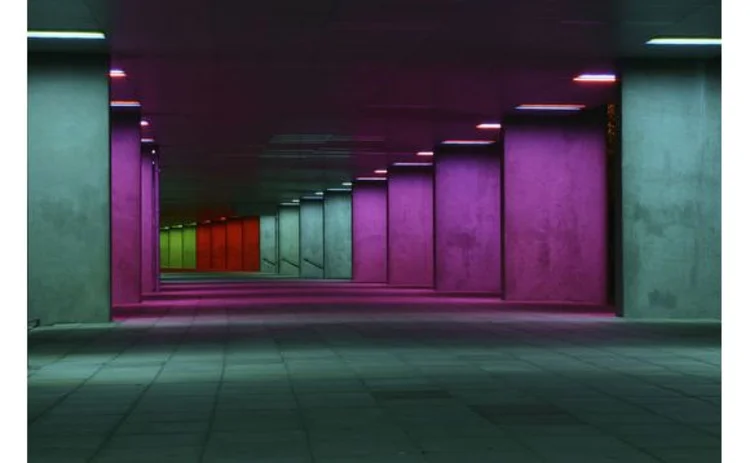 row-of-concrete-columns-diminishing-perspective-lit-at-night-pink-green-red