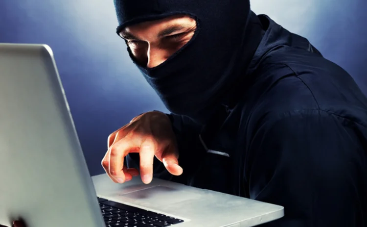 A hacker committing cyber crime on a laptop