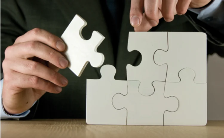 A man putting the final piece of a jigsaw together