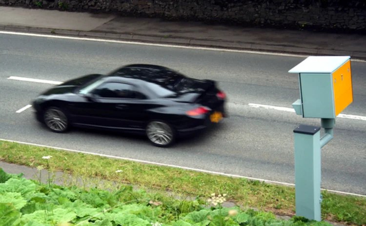A black car passes a speed camera
