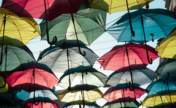 Multiple coloured umbrellas suspended in a sunny sky