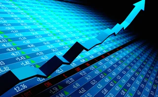 Blue arrow rising over screen showing stock market trading numbers