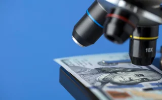 A hundred dollar bill being examined by a microscope