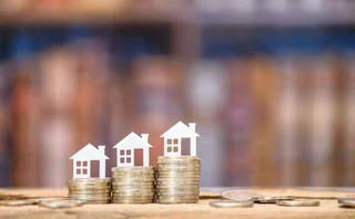 cut out houses on stacks of coins