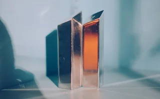 Gold blocks in a white room reflecting light and symbolizing prestige