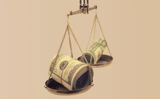 Dollar bills are balanced on a weighing scale