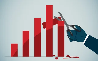 Hand holding scissors cutting down a graph