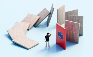 Wooden boards in a circle have started falling down like dominoes as a man scratches his head