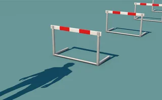 Shadow of a man at the start of a set of hurdles