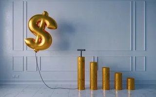 Pumped golden balloon shaped of dollar sign with the growing bar graph on white wall